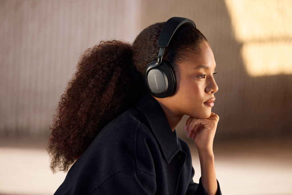 A young woman enjoying some music with the Bowers & Wilkins Px7 S3 wireless audiophile headphones.