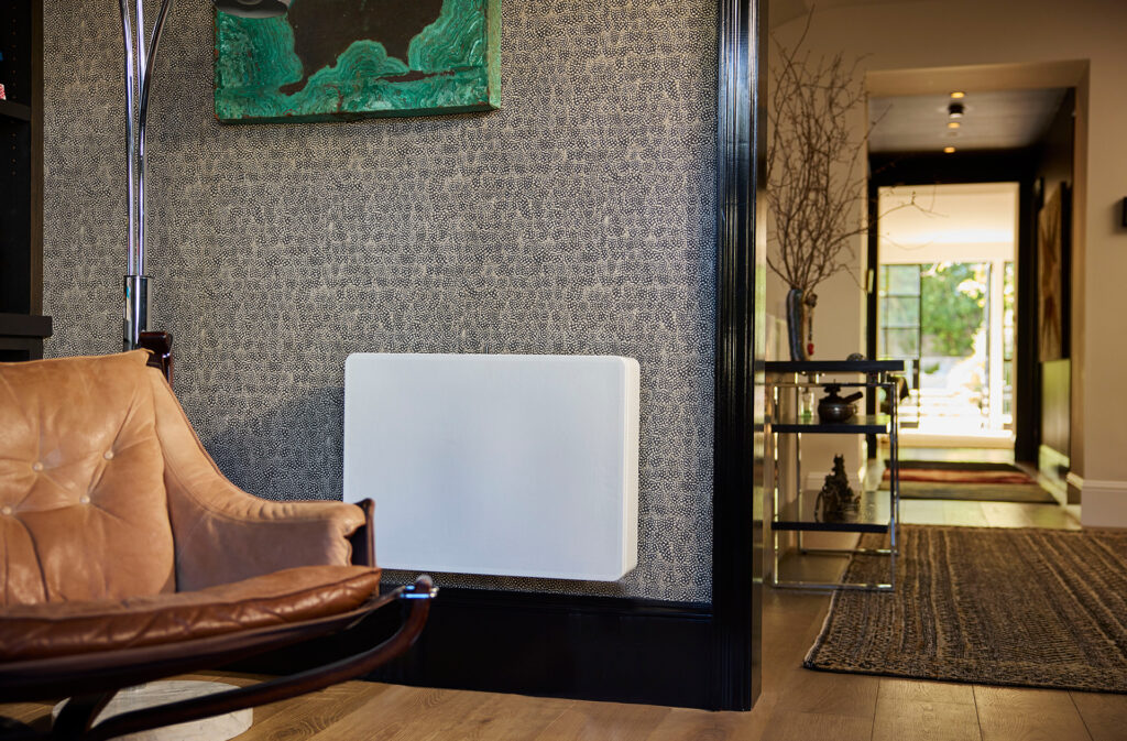 The REL Planar PL-2 subwoofer wall-mounted in a room with wild wallpaper.