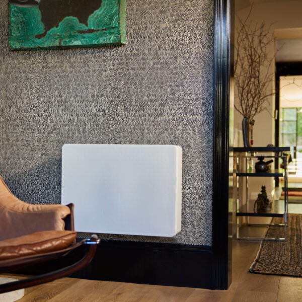 The REL Planar PL-2 subwoofer wall-mounted in a room with wild wallpaper.